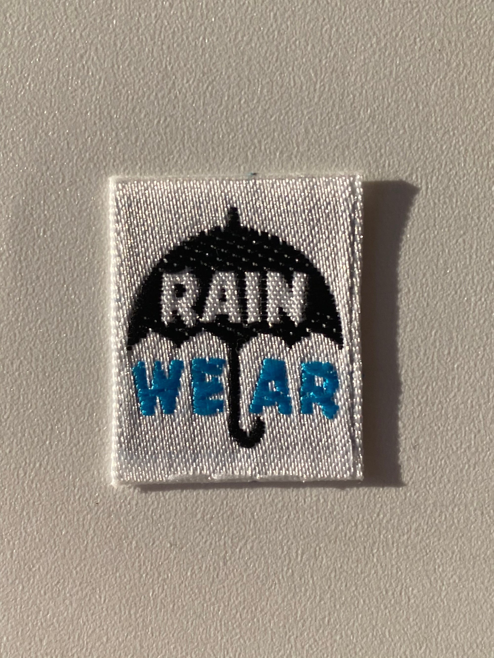 Etiqueta termoadhesiva tejida RAIN WEAR